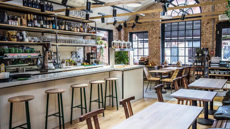 Timber tables, bar stools and a wall of wine in an Antipodea dining room