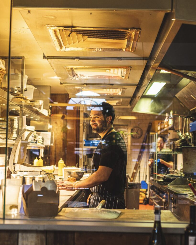 A chef at work behind the pass in an Antipodea kitchen