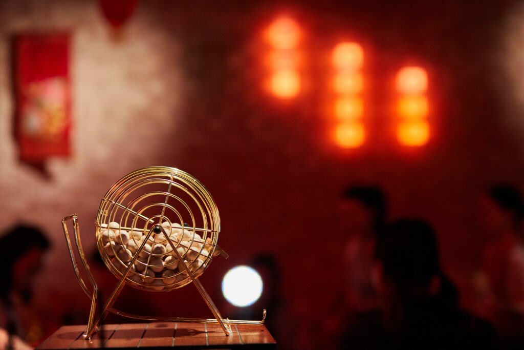 The brass bingo cage at the bar, with red lantern light behind