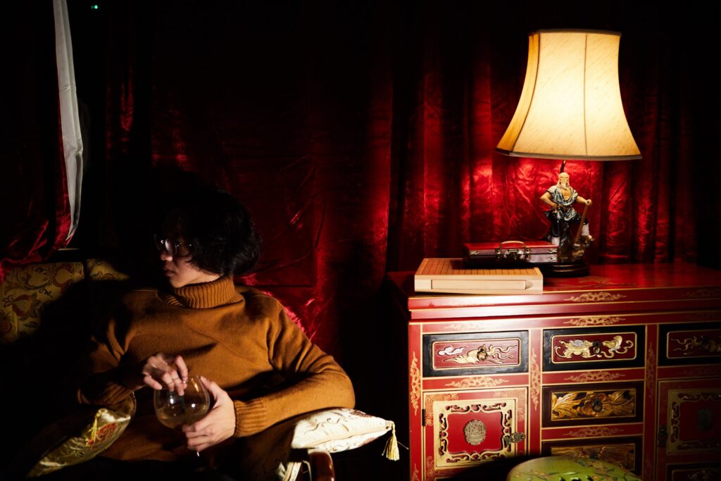 A guest relaxing in the private teahouse, surrounded by red lacquer and velvet