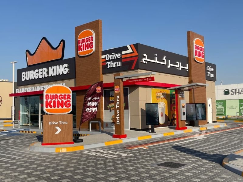 A Burger King drive-thru restaurant with Arabic and English signage