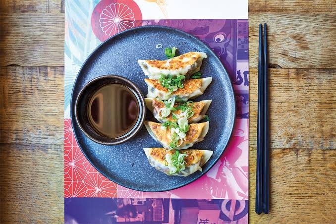 Gyoza with dipping sauce on a patterned placemat