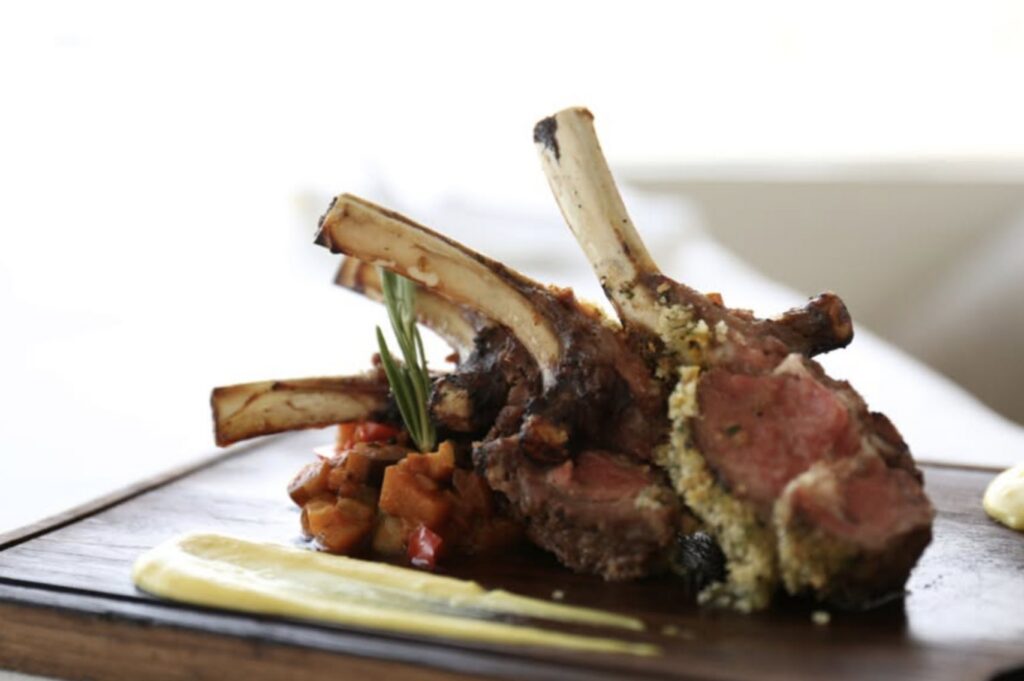 Rack of lamb with a herb crust, served on a timber board