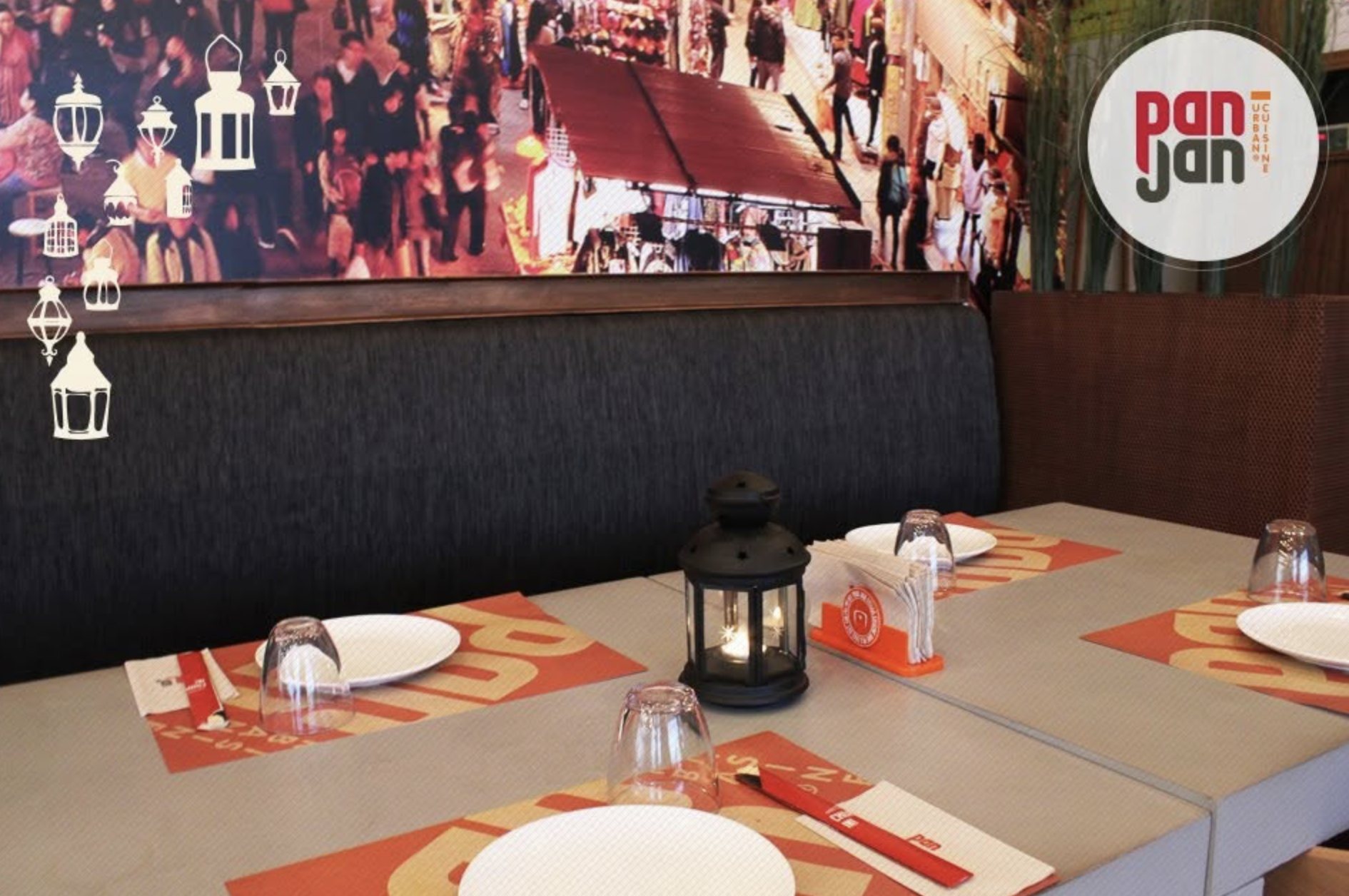 The Pan Jan dining room in Jeddah, with an Asian street-market mural and branded placemats