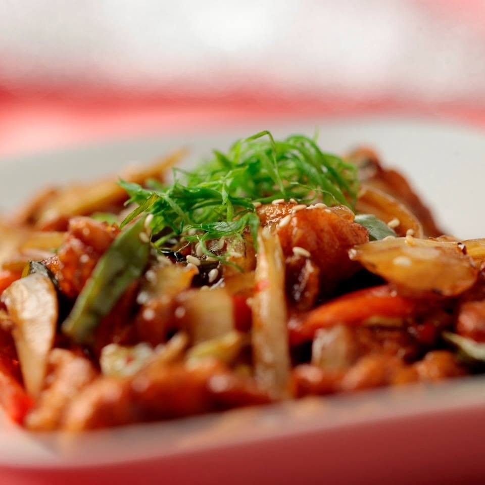A wok-fried dish topped with spring onion