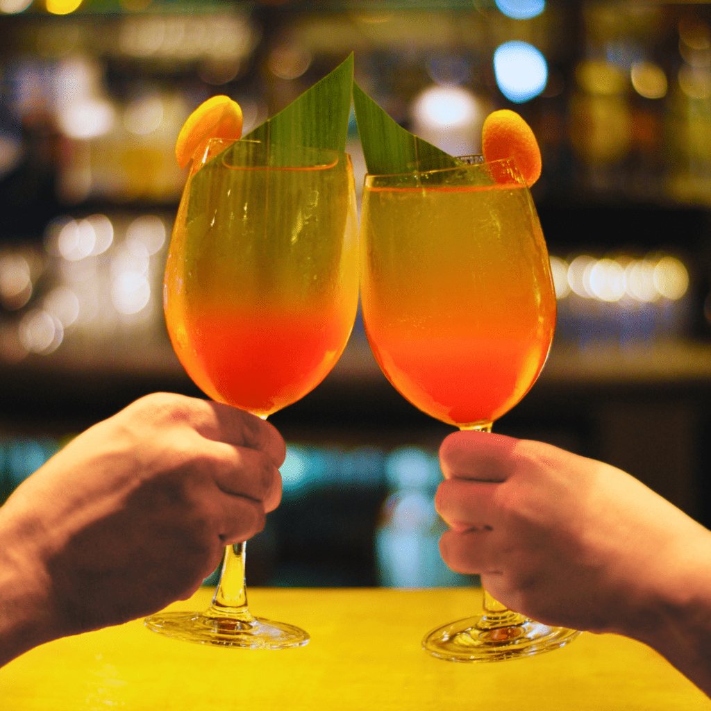Two calamansi spritz cocktails raised in a toast