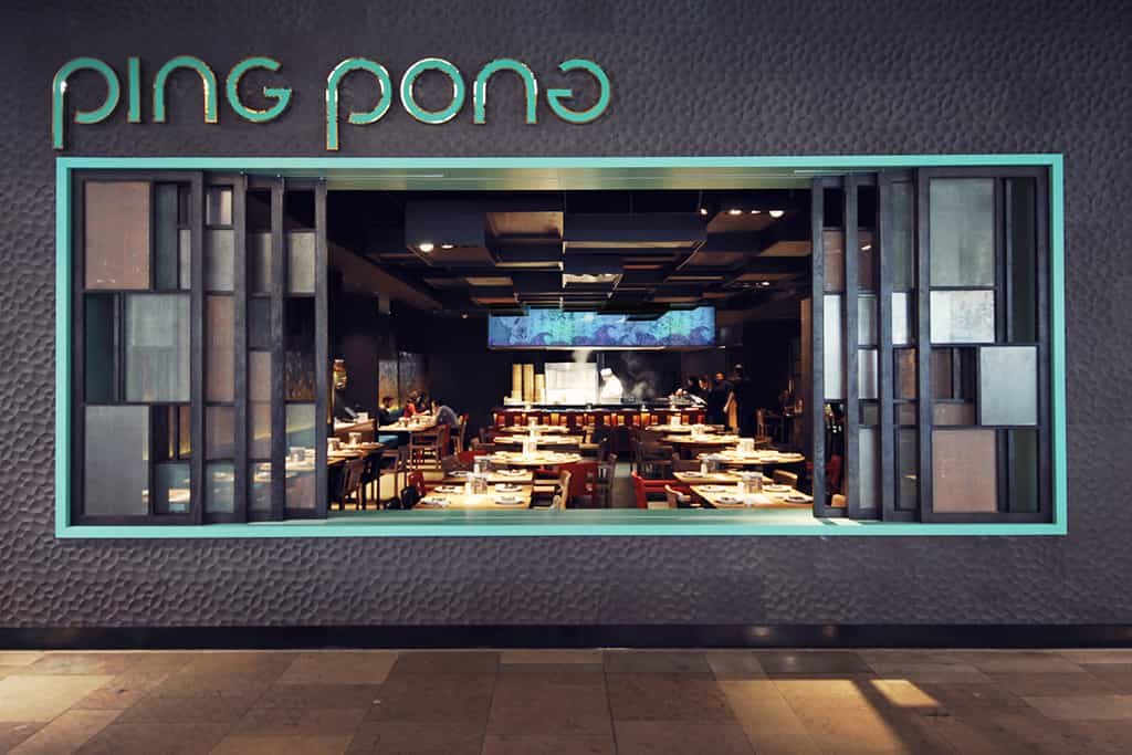 A Ping Pong shopfront with its neon logo and the dining room beyond
