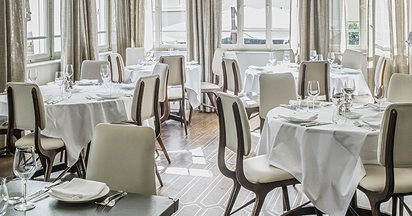 White tablecloths and curved chairs in the restaurant at The Norman